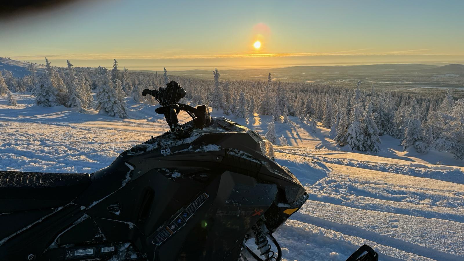 Schneemobil bei Sonnenuntergang
